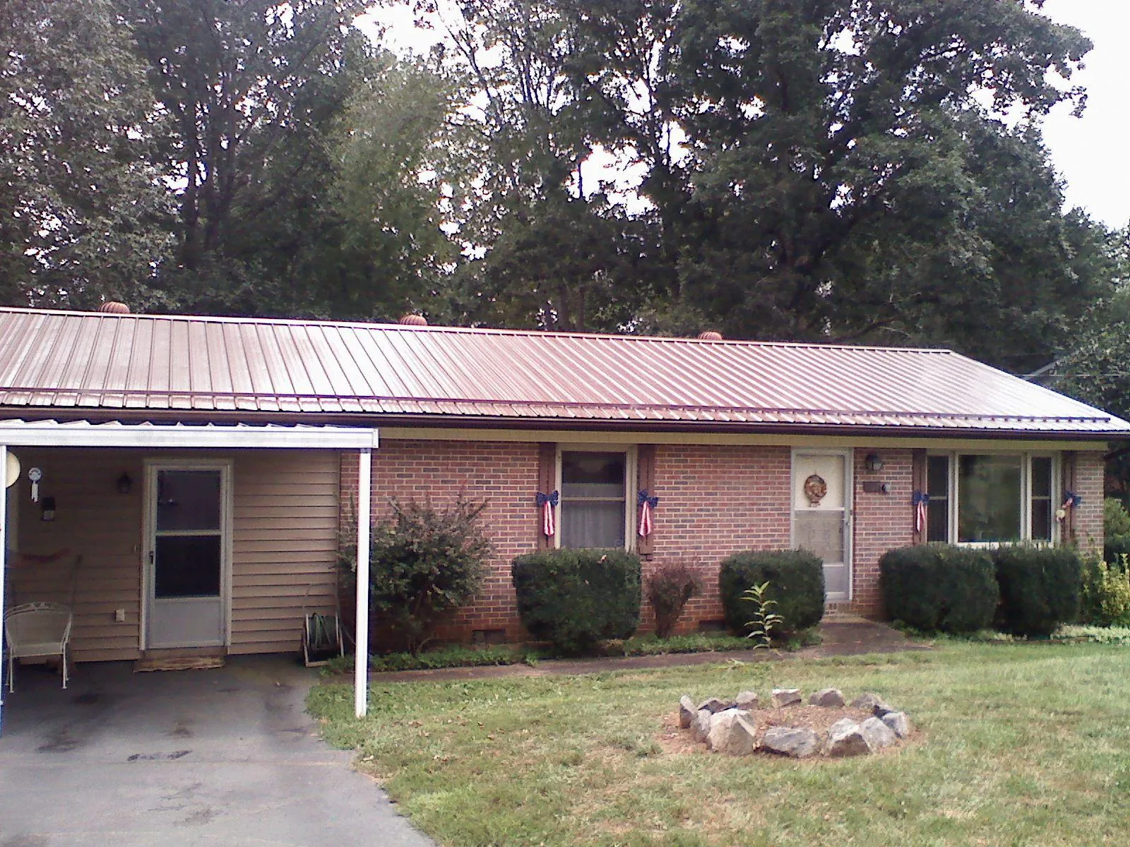Bronze metal roof and carport on a brick ranch home — Roof Repair work by our crew in Genesee